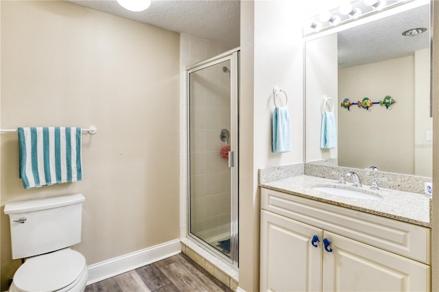 bathroom with wood-type flooring, toilet, a shower with door, and vanity