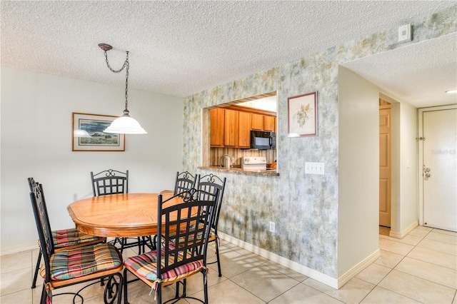 dining space featuring a textured ceiling and light tile patterned floors