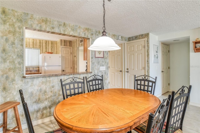 dining room with a textured ceiling and light tile patterned flooring