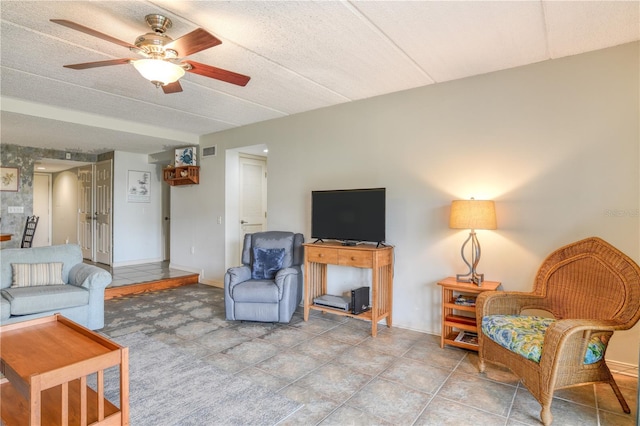 living room with ceiling fan and a textured ceiling