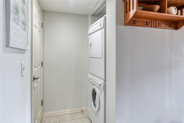 laundry room featuring stacked washer / dryer and light tile patterned floors