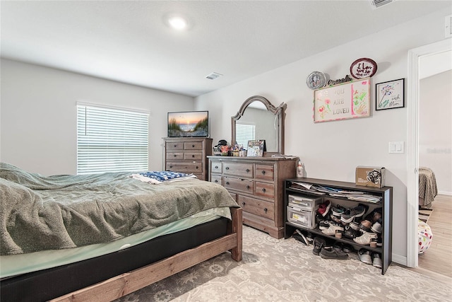 bedroom with light wood-type flooring and visible vents