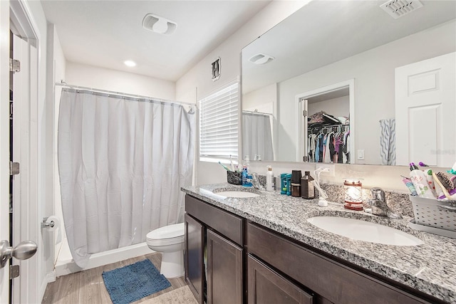 full bath featuring a spacious closet, double vanity, a sink, and visible vents