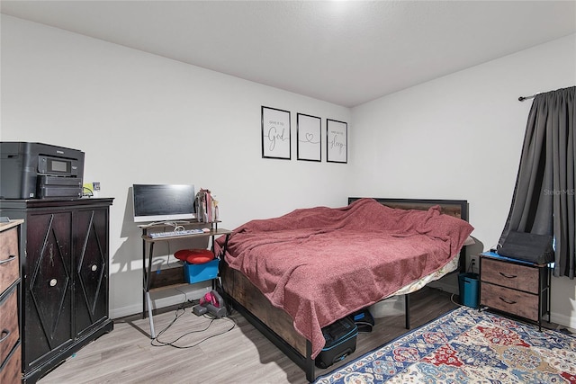 bedroom with light wood-type flooring and baseboards