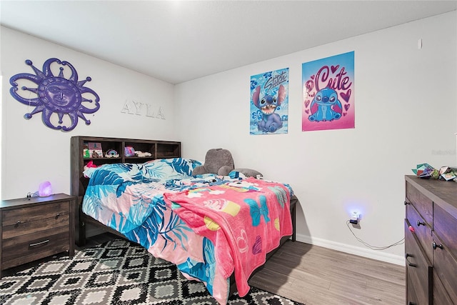 bedroom featuring baseboards and wood finished floors