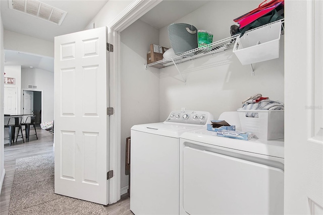 laundry area featuring light wood-type flooring, laundry area, visible vents, and washing machine and clothes dryer