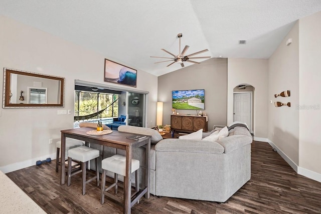 living room with ceiling fan, vaulted ceiling, dark hardwood / wood-style floors, and a textured ceiling