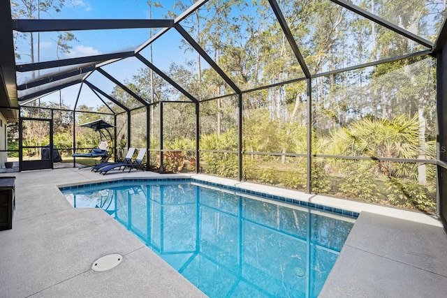 view of swimming pool featuring a patio area and glass enclosure