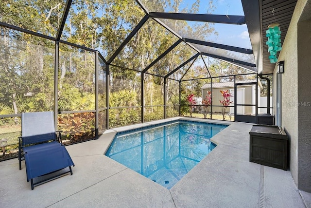 view of swimming pool with an outbuilding, a lanai, and a patio area