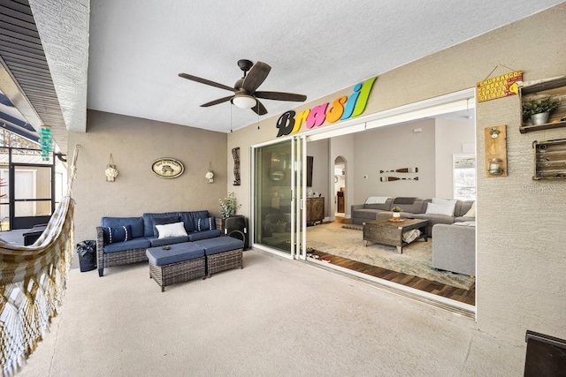 living room with ceiling fan and a textured ceiling