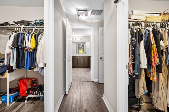 spacious closet with dark hardwood / wood-style floors