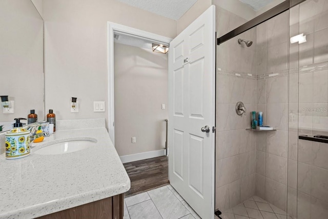 bathroom with vanity, tile patterned floors, a textured ceiling, and walk in shower