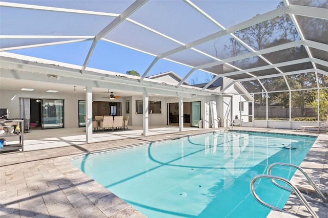 view of swimming pool featuring ceiling fan, glass enclosure, and a patio