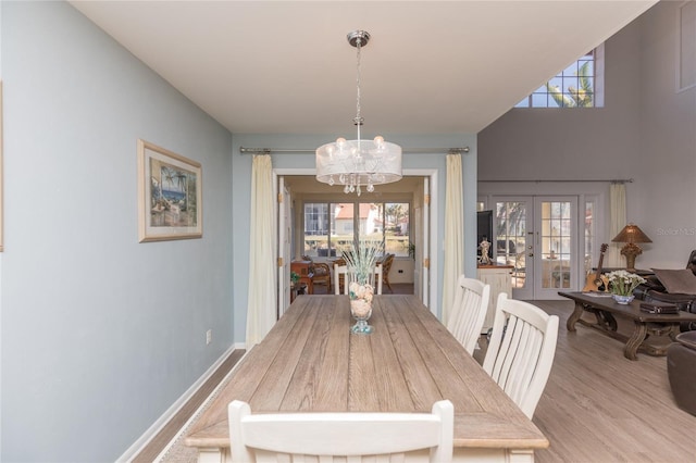 dining room featuring french doors, light hardwood / wood-style floors, and an inviting chandelier