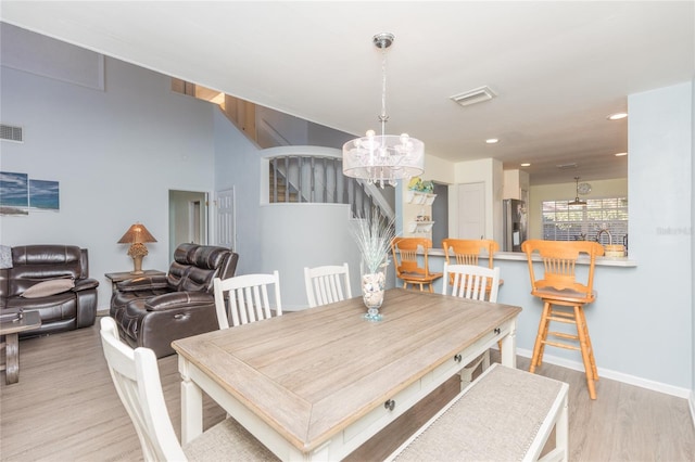 dining area featuring light hardwood / wood-style flooring and a chandelier