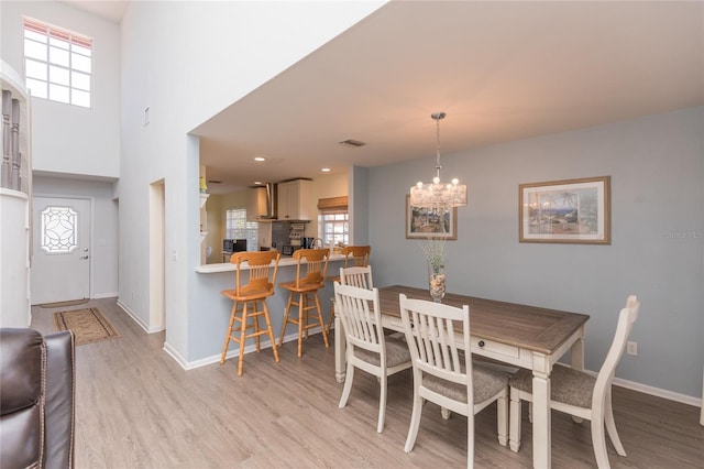 dining space with a notable chandelier and light hardwood / wood-style flooring