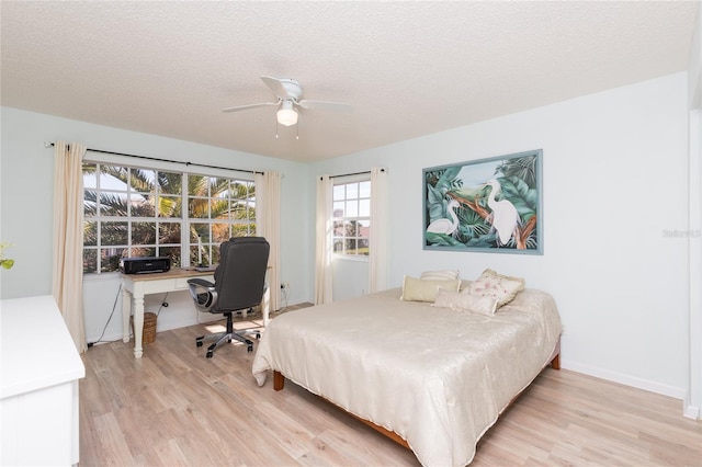 bedroom featuring a textured ceiling, ceiling fan, and light hardwood / wood-style flooring