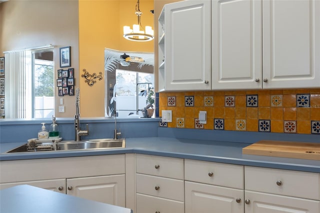 kitchen with white cabinetry, pendant lighting, and tasteful backsplash
