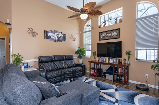 living room featuring dark wood-type flooring, a wealth of natural light, and ceiling fan
