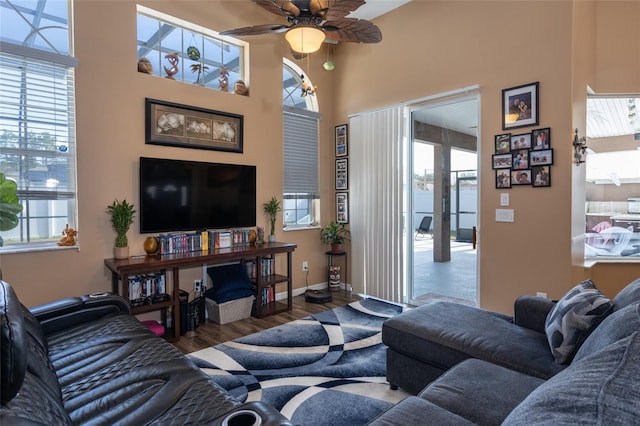living room with ceiling fan, plenty of natural light, and dark hardwood / wood-style flooring