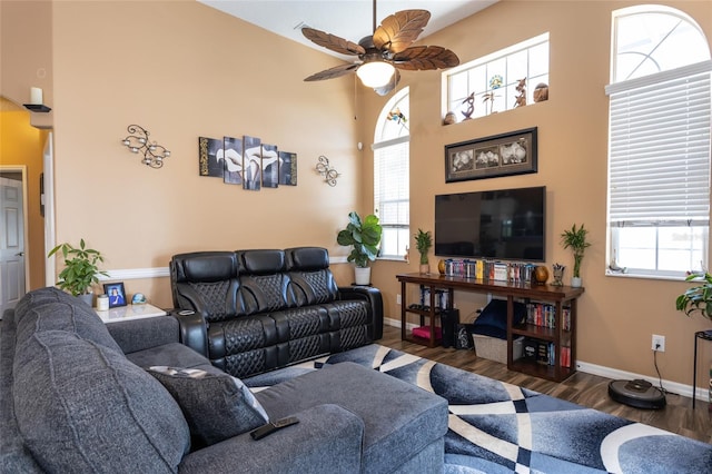 living room with a healthy amount of sunlight, dark wood-type flooring, and ceiling fan