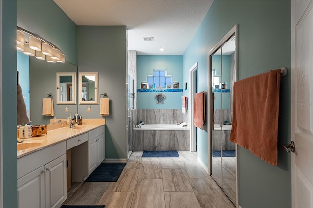 bathroom with vanity and a relaxing tiled tub