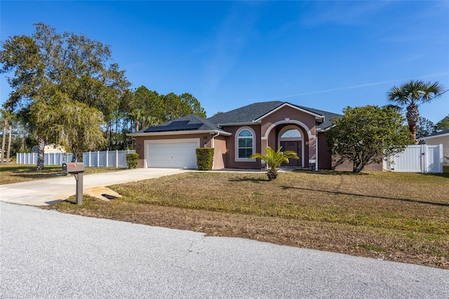 ranch-style house featuring a garage, a front yard, and solar panels