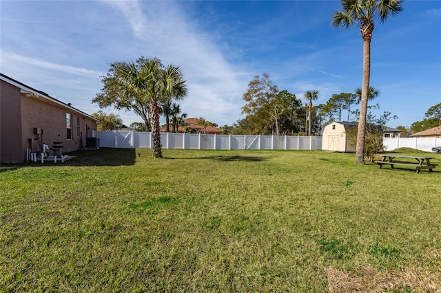 view of yard featuring central AC unit and a storage unit