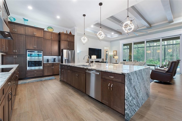 kitchen with appliances with stainless steel finishes, sink, and a large island with sink