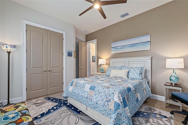 bedroom featuring wood-type flooring, ceiling fan, and a closet