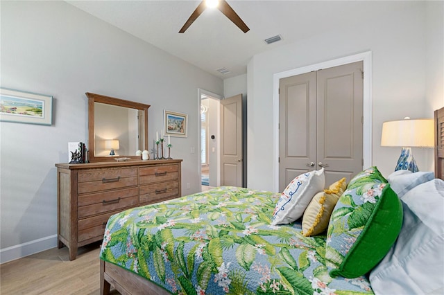 bedroom with light hardwood / wood-style flooring, ceiling fan, and a closet