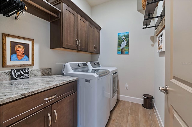 clothes washing area featuring cabinets and washer and clothes dryer