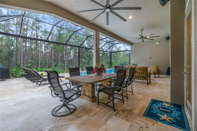 view of patio / terrace featuring ceiling fan and glass enclosure