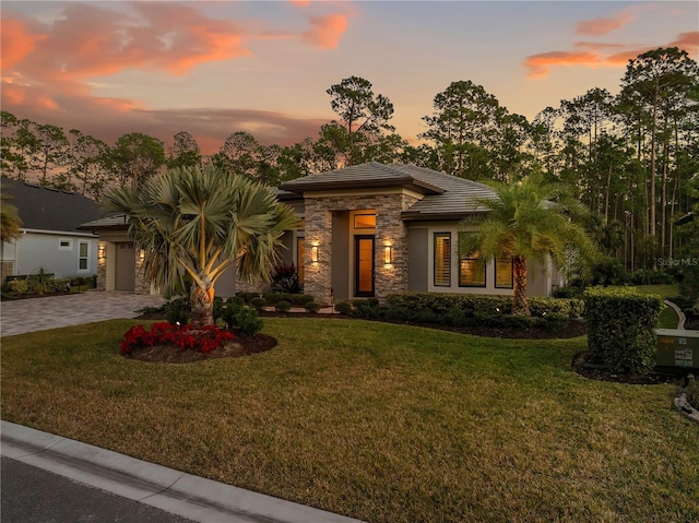 view of front of property with a garage and a lawn