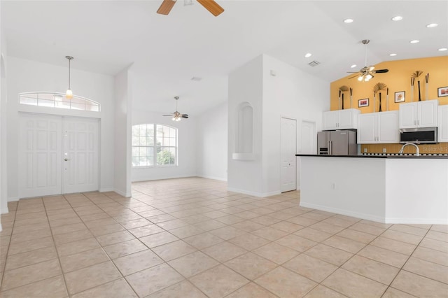 interior space with light tile patterned floors, high vaulted ceiling, and ceiling fan