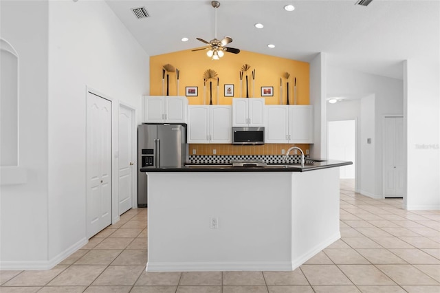 kitchen with backsplash, lofted ceiling, stainless steel appliances, and white cabinets