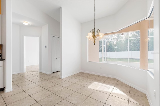 unfurnished dining area with light tile patterned floors and a notable chandelier