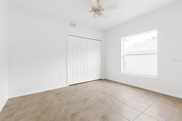 unfurnished bedroom featuring light tile patterned floors, a closet, and ceiling fan