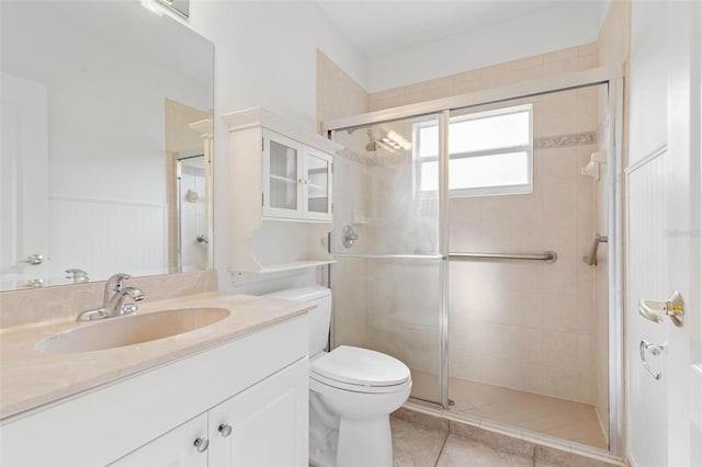 bathroom featuring vanity, tile patterned floors, a shower with door, and toilet