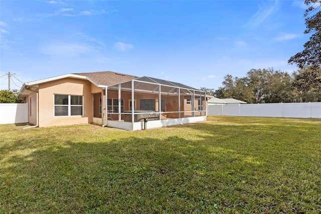 rear view of property featuring a lanai and a yard