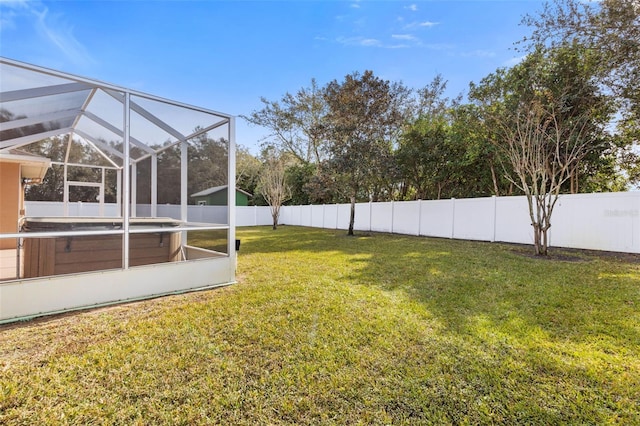 view of yard featuring a hot tub and glass enclosure