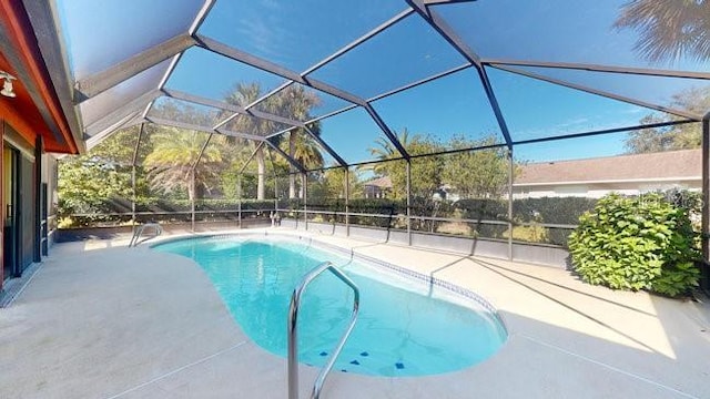 view of swimming pool featuring glass enclosure and a patio