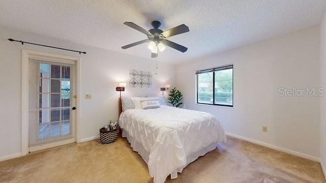 carpeted bedroom with ceiling fan and a textured ceiling