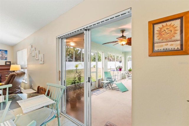 entryway with ceiling fan, light colored carpet, and a textured ceiling