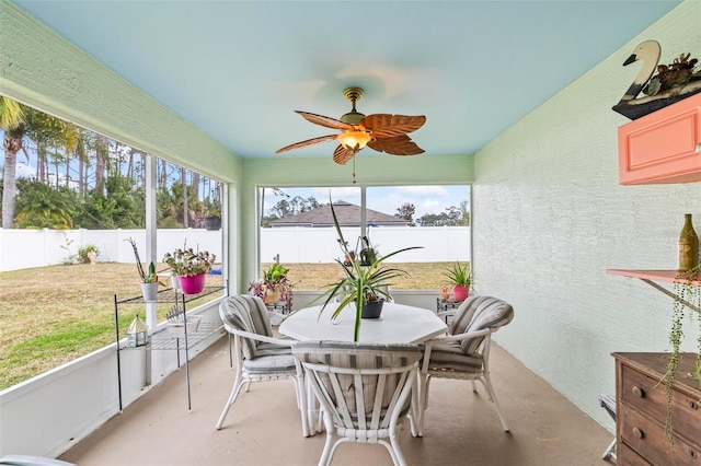 sunroom featuring ceiling fan and plenty of natural light