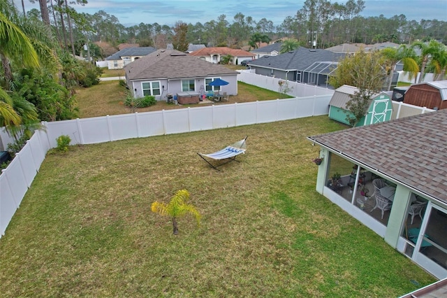 view of yard with a sunroom and a storage unit