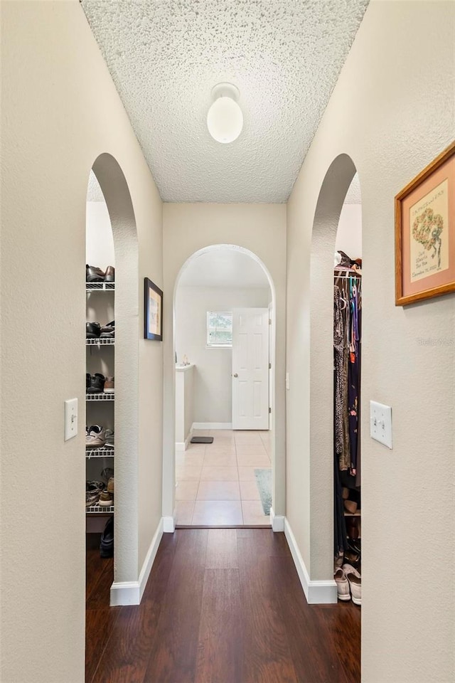 hall featuring a textured ceiling and wood-type flooring