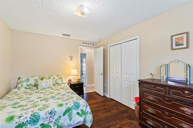 bedroom featuring a textured ceiling, dark hardwood / wood-style floors, and a closet