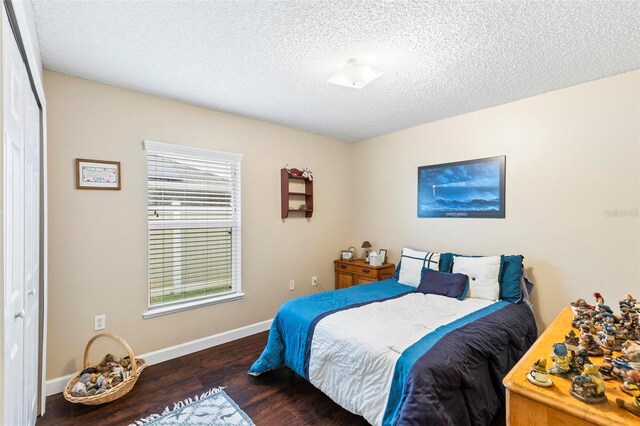 bedroom featuring dark wood-type flooring, a textured ceiling, and a closet