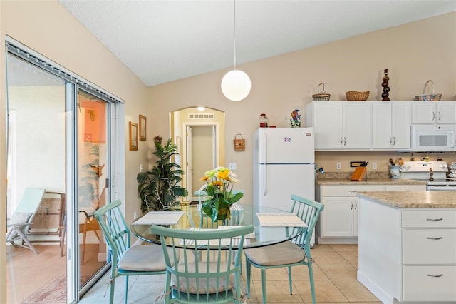 kitchen with white appliances, light stone countertops, light tile patterned floors, white cabinets, and pendant lighting